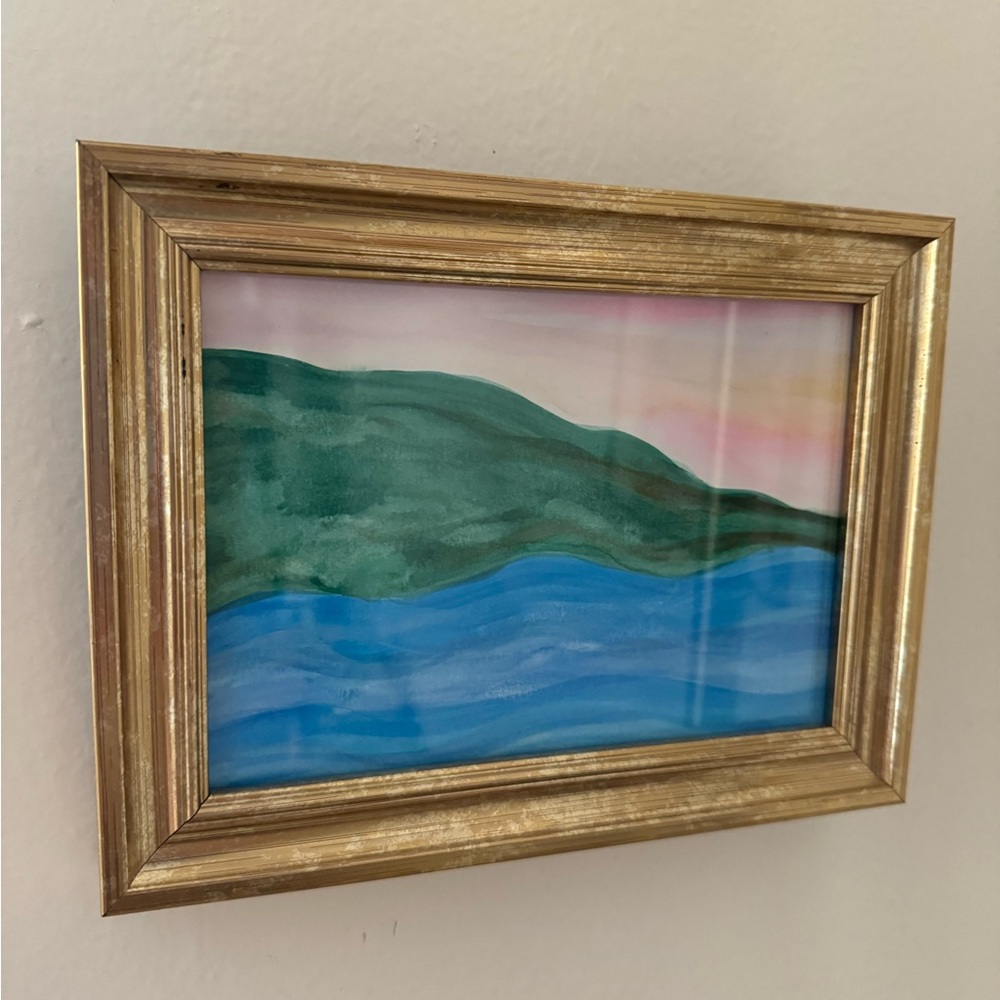 Costal painting with gold frame.